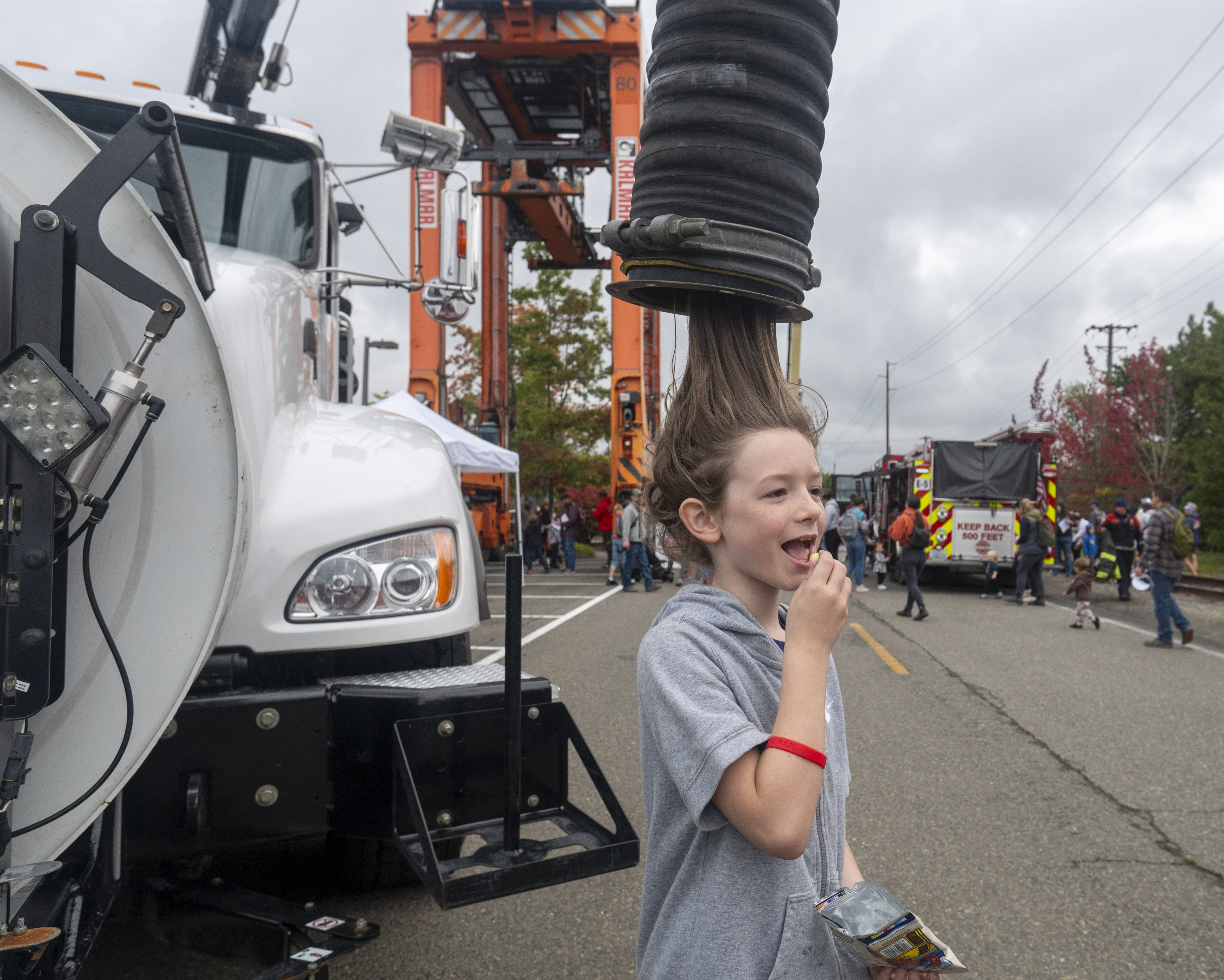 A happy young boy's hair appears to be sucked up through a black tube.