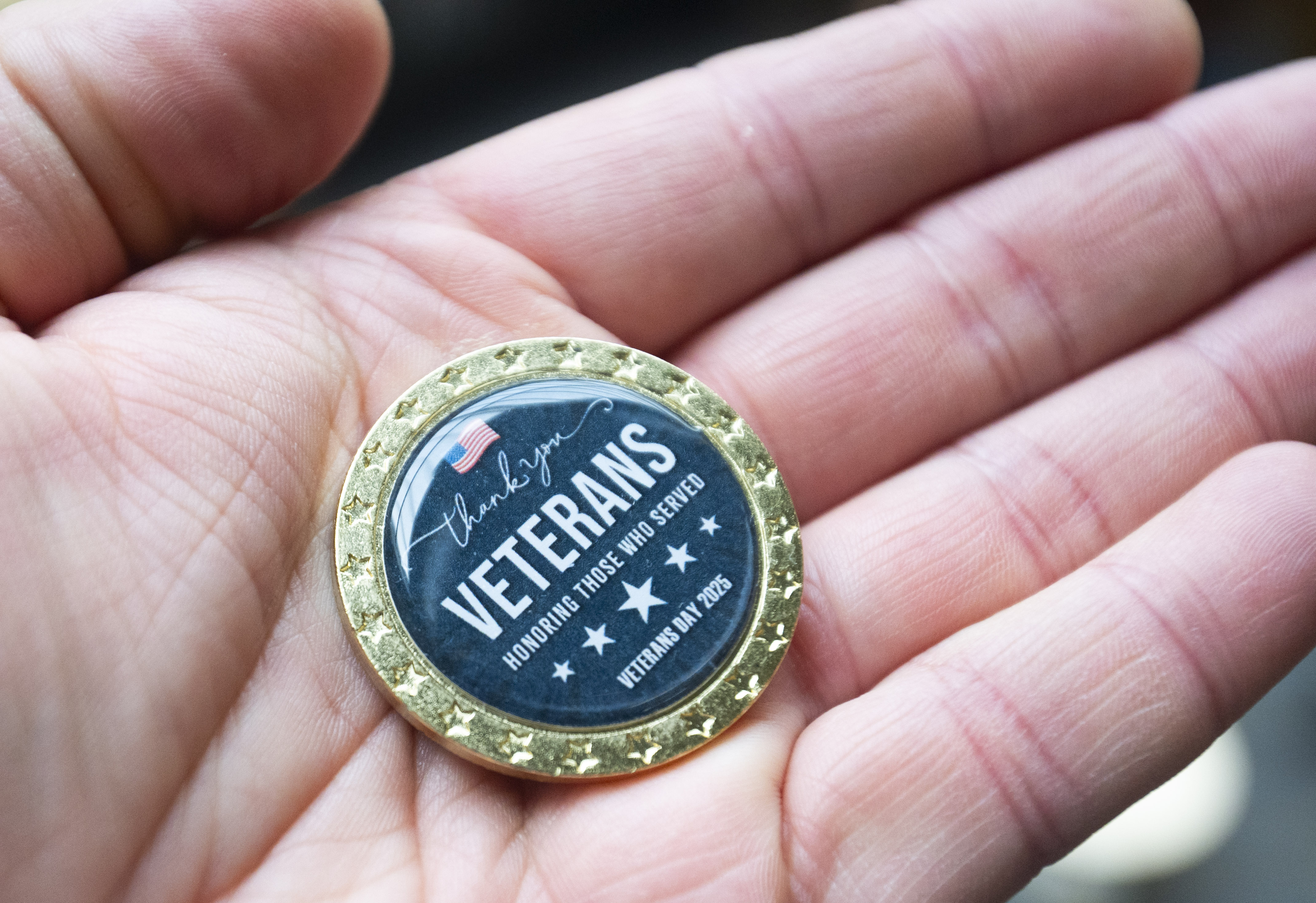 A Veterans Day coin being held. 