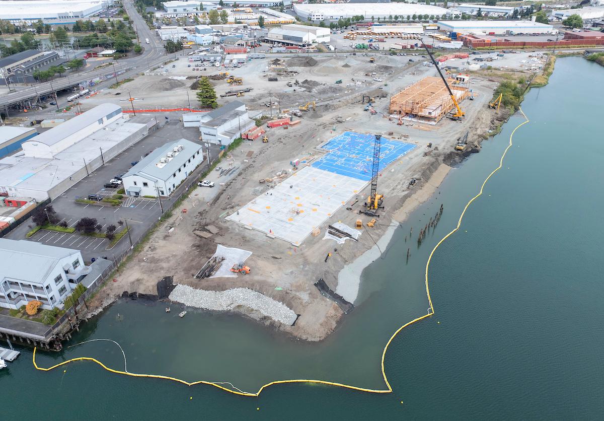 Drone footage of construction happening along a body of water.